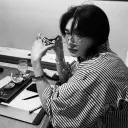 Multilingual Hwang Hyunjin na tumutuon sa mga gawain sa chat IA, ang core ng neural network na nakikita sa background.