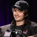 Multilingual Joe Keery focusing on chat IA tasks, neural network core visible in background.